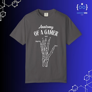 May include: Dark gray t-shirt with the text "Anatomy of a Gamer" and a white skeletal hand graphic. The design includes "W, A, S, D" keys and "Shift/Ctrl" and "Space" labels.