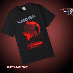 May include: Black t-shirt with a red graphic of a figure and the word "SAMURAI" in gray. The text "REUNION TOUR 2020" is printed in red below the graphic. The shirt has a crew neck and short sleeves.