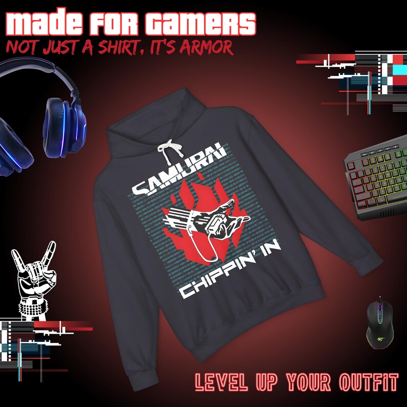 Op de afbeelding: Een donkergrijze hoodie met de tekst "SAMURAI CHIPPIN' IN" en een afbeelding van een hand en vlammen. De afbeelding bevat ook een toetsenbord, muis en koptelefoon, met de tekst "MADE FOR GAMERS" en "LEVEL UP YOUR OUTFIT".