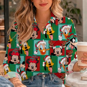 May include: A long-sleeved button-down shirt featuring a repeating pattern of Disney characters including Mickey Mouse, Pluto, Donald Duck, and Minnie Mouse wearing Christmas hats and reindeer antlers against a green and red grid background.