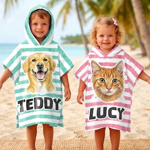May include: Two children wearing hooded beach towels. One towel is teal and white striped with a golden retriever graphic and the name "TEDDY". The other is pink and white striped with a cat graphic and the name "LUCY".