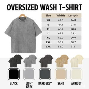 Puede incluir: Una camiseta gris lavado de gran tama&ntilde;o cuelga de una percha de madera. La imagen incluye una tabla de tallas con medidas en cm y opciones de color: negro, gris claro, gris oscuro, arena y albaricoque. El texto "OVERSIZED WASH T-SHIRT" est&aacute; en la parte superior.