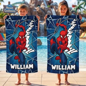 May include: Two blue beach towels featuring Spider-Man in a dynamic pose, with the word "WILLIAM" printed at the bottom. The towels have a web-like pattern and the word "YEEAAAH!" in white.