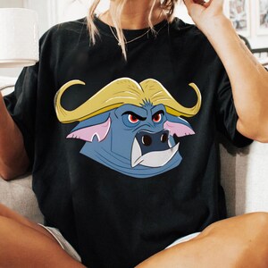May include: Black t-shirt featuring a cartoon buffalo head with a yellow mane, blue face, and red eyes. The buffalo has a stern expression. The shirt is a casual wear item.