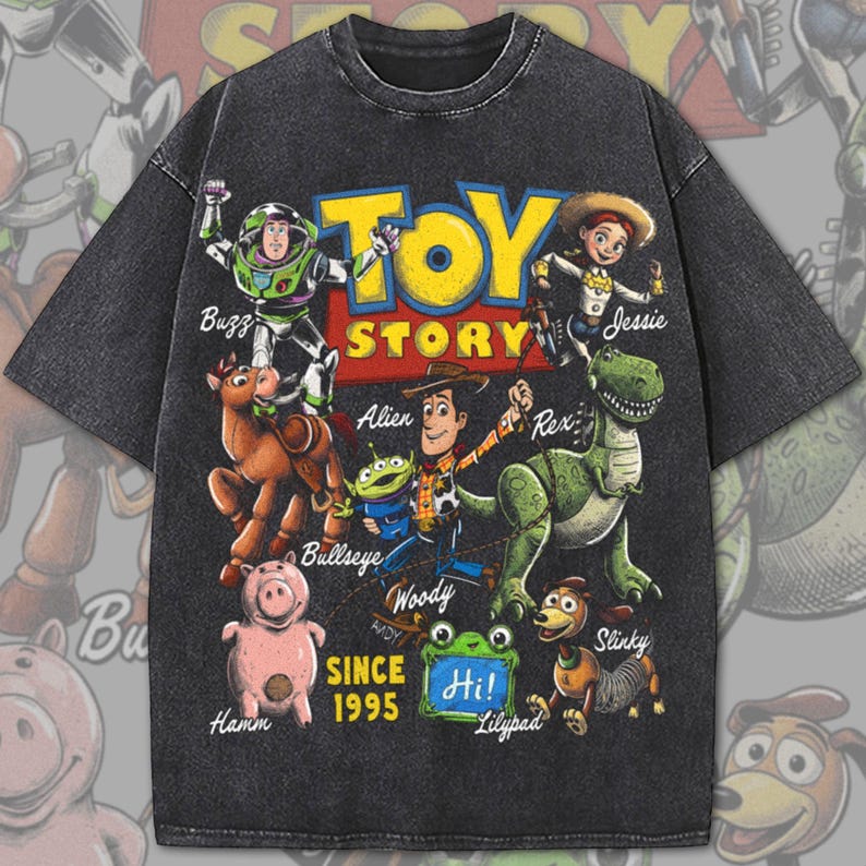 Pode incluir: Uma t-shirt de manga curta cinzento-carv&atilde;o com uma impress&atilde;o gr&aacute;fica das personagens de Toy Story, incluindo Buzz, Jessie, Bullseye, Alien, Woody, Rex, Hamm e Slinky. O texto diz Toy Story, Since 1995 e Hi num quadrado verde.