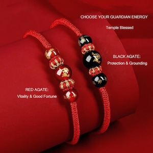 Op de afbeelding: Twee rode koordarmbanden met agaatkralen. Eén heeft rode agaatkralen met gouden accenten, de andere heeft zwarte agaatkralen met gouden ontwerpen. Tekst luidt "CHOOSE YOUR GUARDIAN ENERGY" en "RED AGATE: Vitality & Good Fortune".