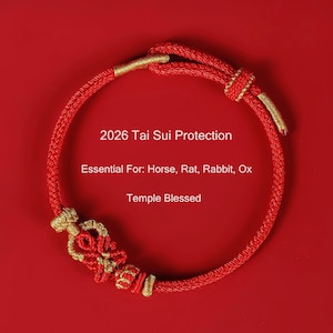 May include: Red braided bracelet with gold accents and decorative knot. The text on the image reads "2026 Tai Sui Protection" and "Essential For: Horse, Rat, Rabbit, Ox" and "Temple Blessed". The bracelet is set against a red background.