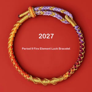 May include: A circular braided bracelet featuring a gradient of orange, purple, and gold metallic threads. The text 2027 and Period 9 Fire Element Luck Bracelet is centered within the loop. The bracelet has a sliding knot closure with gold ends.
