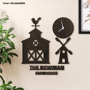 May include: A wooden wall clock and decorative farm-themed cutouts in a dark brown color. The clock has a round face with black numbers and hands. The cutouts include a barn, windmill, and the text "THE NEWMAN FARMHOUSE".