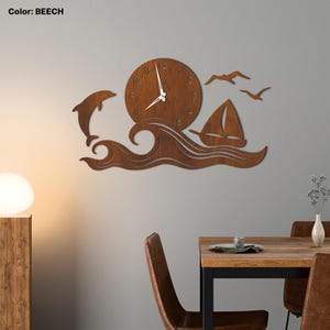Op de afbeelding: Houten wandklok met een nautisch thema. De klok heeft een ronde wijzerplaat met cijfers, een dolfijn die uit golven springt, een zeilboot en zeemeeuwen. De klok is gemaakt van hout en heeft een natuurlijke afwerking. De kleur is beuk.