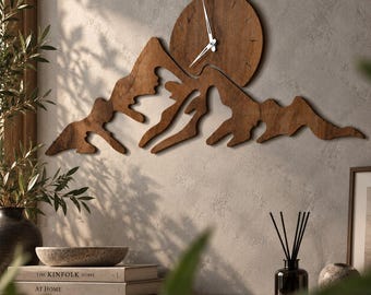 May include: A wall clock crafted from dark brown wood, featuring a mountain range silhouette integrated with a circular sun design. The clock face is embedded within the sun shape, displaying thin silver hands against the wood grain texture.