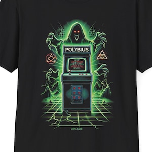 May include: Black t-shirt featuring a green and black graphic of a ghost holding a vintage arcade game with the text "Polybius" on it. The text "Arcade" is below the graphic.