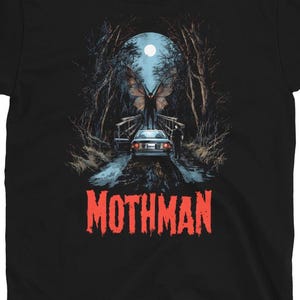 Pode incluir: Camiseta preta com um gráfico Mothman. O design retrata um carro numa estrada, uma ponte e uma criatura alada sob a lua cheia. A palavra "MOTHMAN" está em texto vermelho estilizado. A camisa tem o logotipo "SLEEPLESS THREADS".