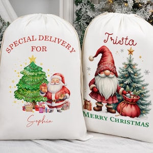 May include: Two white Christmas gift sacks with drawstring closures. One sack features a Santa Claus illustration with a Christmas tree and the text "Special Delivery For Sophia." The other sack has a gnome illustration, a Christmas tree, and the text "Trista Merry Christmas."