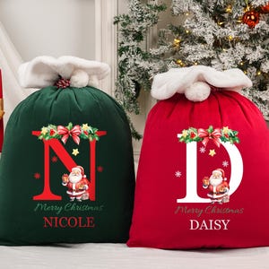May include: Two Christmas gift sacks, one green and one red, with white fluffy tops. The green sack has a large red "N" with a Santa illustration, the red sack has a white "D" with a Santa illustration. Both say "Merry Christmas".