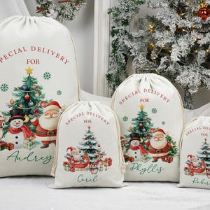 May include: Four cream-coloured Christmas gift sacks with drawstring closures. Each sack features a festive design with a Christmas tree, Santa Claus, a snowman, and the text "SPECIAL DELIVERY FOR" with a name below.