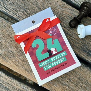 Może przedstawiać: Czerwono-biały kalendarz adwentowy z zieloną liczbą 24 i tekstem "Chess Puzzles for Advent". Kalendarz ma czerwoną kokardkę i napis "No. 1" na białym kółku.
