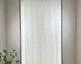 Könnte beinhalten: Weißer, durchsichtiger Vorhang mit einem gestickten Blumenmuster und einem gewellten Saum.