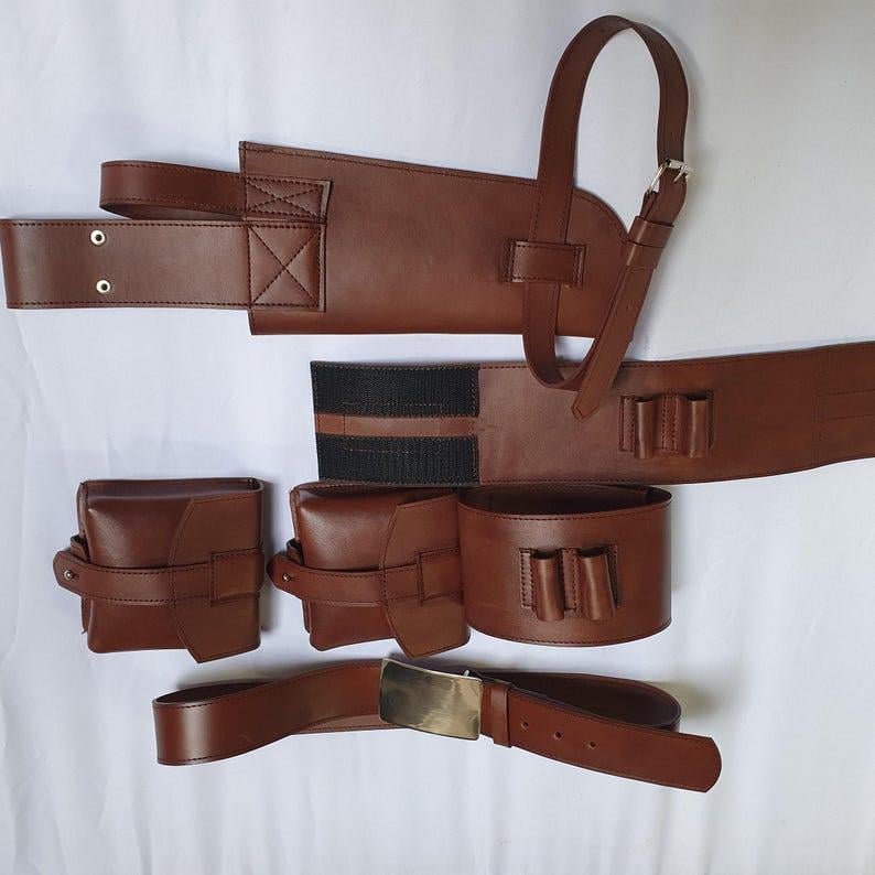 Puede incluir: Un conjunto de cintur&oacute;n utilitario de cuero marr&oacute;n. Cuenta con m&uacute;ltiples bolsas, un cintur&oacute;n con hebilla dorada y una correa para el hombro. El conjunto incluye dos bolsas peque&ntilde;as, una m&aacute;s grande y un cintur&oacute;n con tres peque&ntilde;os lazos.