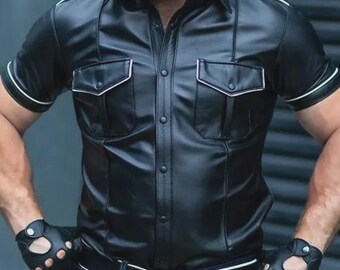 May include: Black leather short-sleeve shirt with two chest pockets and white trim. The shirt has a button-up front and a collar. The sleeves have white trim. The shirt is paired with blue jeans and a black belt.