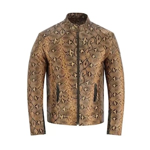 Puede incluir: Una chaqueta de cuero marrón con estampado de piel de serpiente. La chaqueta tiene una cremallera y dos bolsillos en la parte delantera.