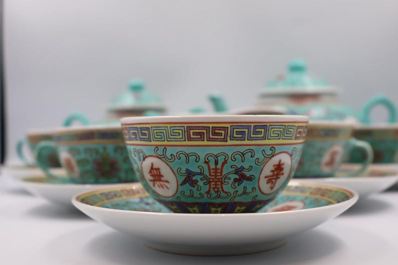 Puede incluir: Juego de t&eacute; de porcelana con dise&ntilde;o turquesa y dorado. El juego incluye tazas, platillos y una tetera. Las tazas y los platillos tienen una base blanca con un borde con dibujos turquesa y dorado.