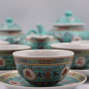 Puede incluir: Un juego de t&eacute; turquesa completo con tazas, platillos, tetera y cremera a juego. Las tazas y platillos tienen un borde decorativo con caracteres chinos. El juego est&aacute; dise&ntilde;ado con un patr&oacute;n floral.