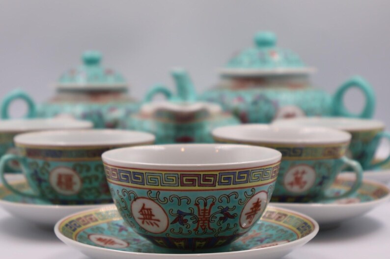 Puede incluir: Un juego de t&eacute; turquesa completo con tazas, platillos, tetera y cremera a juego. Las tazas y platillos tienen un borde decorativo con caracteres chinos. El juego est&aacute; dise&ntilde;ado con un patr&oacute;n floral.