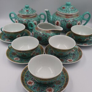 Puede incluir: Un juego de t&eacute; completo con un dise&ntilde;o floral turquesa y dorado. El juego incluye dos teteras, una lechera, seis tazas y platillos. Las tazas y platillos tienen un di&aacute;metro de aproximadamente 10 cm.