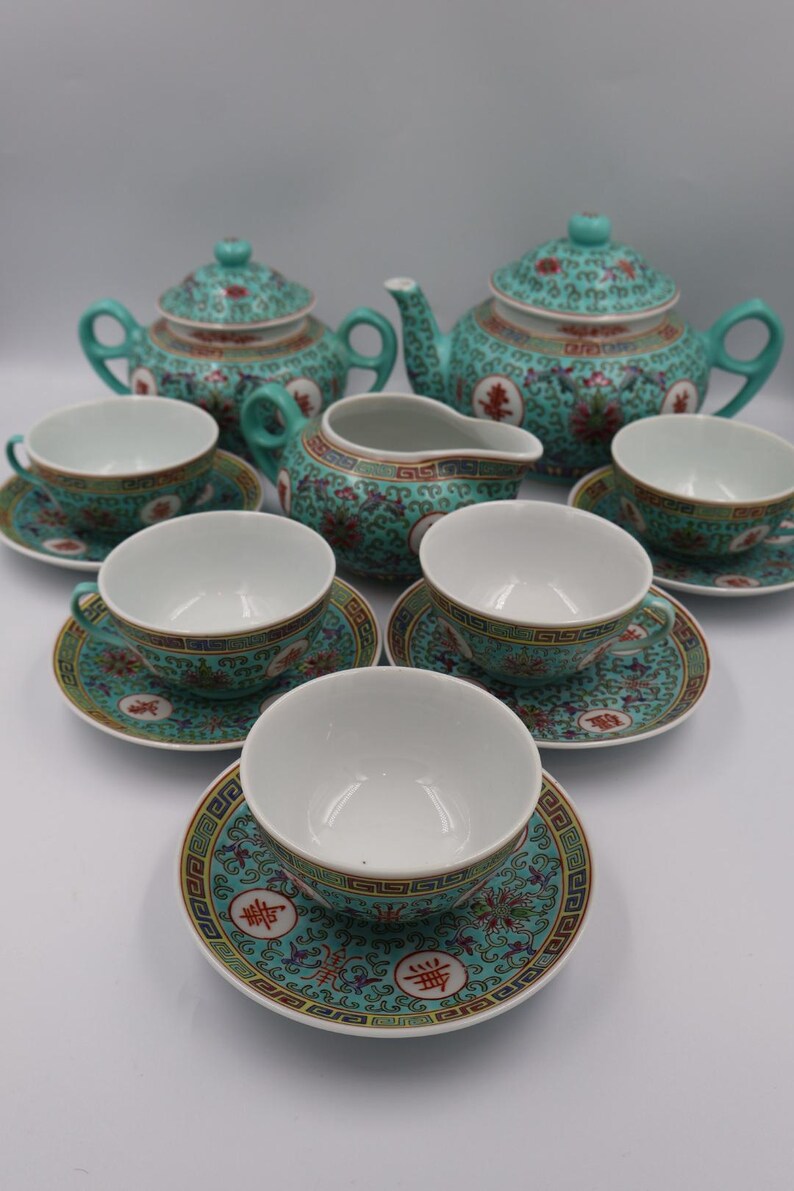 Puede incluir: Un juego de t&eacute; completo con un dise&ntilde;o floral turquesa y dorado. El juego incluye dos teteras, una lechera, seis tazas y platillos. Las tazas y platillos tienen un di&aacute;metro de aproximadamente 10 cm.