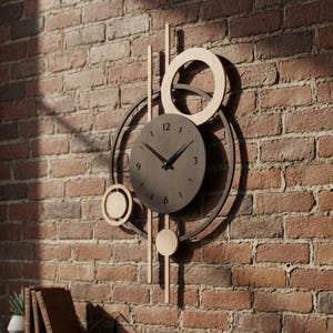 May include: A modern wall clock with a dark gray face and black hands, surrounded by a geometric design of circles and lines in gold and black. The clock is mounted on a red brick wall, creating a striking contrast.