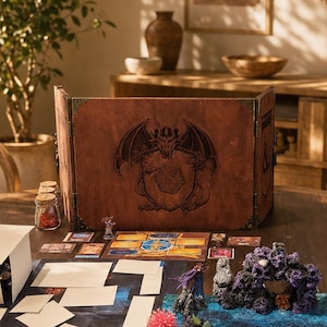 May include: A tabletop role-playing game setup featuring a brown folding screen with a dragon illustration, a blue and black map board, white paper tiles, small character miniatures, and a cluster of purple rock-like terrain pieces on a table.