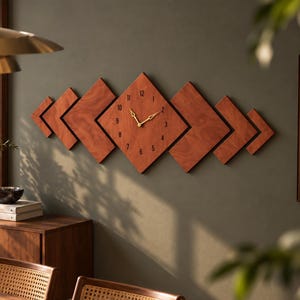 Peut inclure: Une horloge murale composée de plusieurs panneaux en bois en forme de losange disposés horizontalement. Le panneau central présente des chiffres noirs de 1 à 12 et des aiguilles dorées. Le bois a une finition grainée brun-rouge chaud.