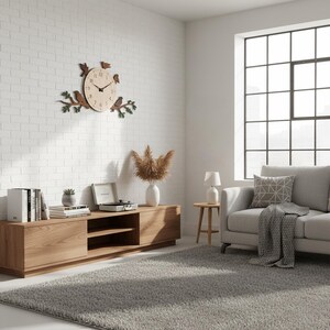 May include: A wooden wall clock with a bird and branch design. The clock has a light-colored face with black hands and numbers. The birds and branches are brown and green. The clock is mounted on a white brick wall in a living room setting.