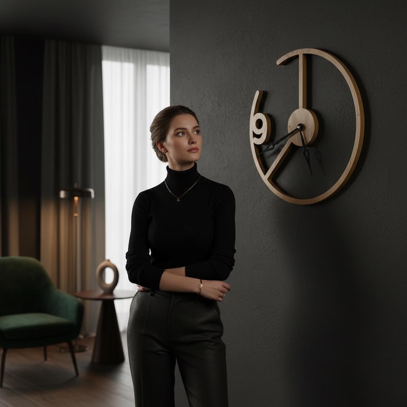 May include: A modern, minimalist wall clock with a light wood finish. The clock features a unique open design with the number 9 prominently displayed. The hands are black, and the clock is mounted on a dark gray wall. The clock's diameter is approximately 18 inches.