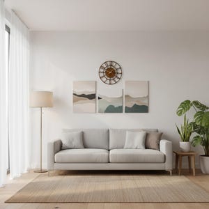 Puede incluir: Un sal&oacute;n moderno con un sof&aacute; gris claro, cojines, una alfombra tejida y una l&aacute;mpara de pie. Encima del sof&aacute; hay tres pinturas de paisajes y un reloj decorativo. Las plantas en macetas a&ntilde;aden un toque natural.
