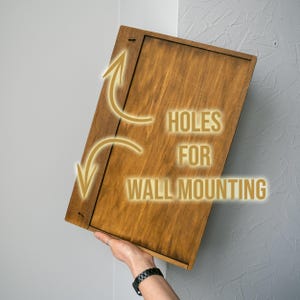 May include: A brown wooden sign with holes for wall mounting. The sign has the text "HOLES FOR WALL MOUNTING" printed on it.