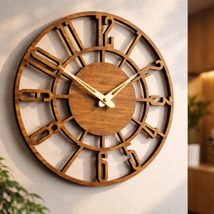 Puede incluir: Un reloj de pared redondo de madera con acabado marrón oscuro. El reloj presenta números recortados y una esfera central circular. Las manecillas del reloj son doradas. El reloj está montado en una pared de color claro.