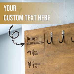 May include: Wooden grilling station sign with hooks, a thermometer, and a fish and chicken icon. The sign says "Jimmy's Grilling Station" and includes the internal cooking temperatures for fish and chicken.
