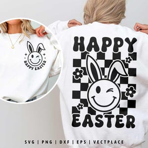 Op de afbeelding: Witte sweatshirt met een zwart-wit Paas-thema grafisch ontwerp. Het ontwerp toont een knipogend konijnengezicht, bloemen en de woorden "Happy Easter". De achterkant van de trui heeft een dambordpatroon met hetzelfde konijnengezicht en tekst.