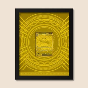 May include: A framed gold-colored collectible trading card featuring a central creature illustration and text including "Overflowing Wishes" and "Mega Symphonia" with a HP value of 360, set against a circular geometric gold background pattern.