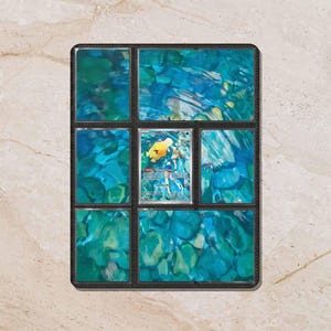 May include: A black trading card binder page featuring eight slots filled with a blue water-themed background insert and one central slot containing a Psyduck Pokémon card with the text Psyduck and 70 HP printed on the card surface.