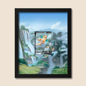 Op de afbeelding: Een ingelijst kunstwerk met een Pokémon-verzamelkaart, Dragonite V, tegen een schilderachtig landschap van watervallen en bergen. De kaart is gecentreerd in het frame en toont het ontwerp en de details.