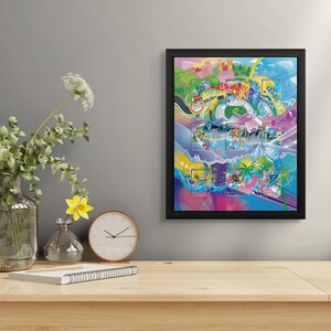 May include: A framed, colorful artwork with a black border is displayed on a wooden table. The artwork features a vibrant, abstract design with various shapes and colors. A clear glass vase with green foliage and white flowers, a yellow flower in a small vase, and a clock are also on the table.