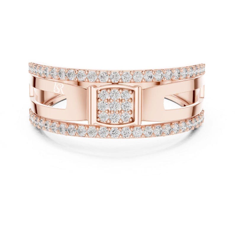 May include: Rose gold ring with a rectangular center and a band of small, sparkling diamonds. The ring has a unique design with cut-out sections and a double row of diamonds along the top and bottom edges. The ring is set against a white background.