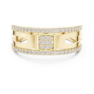 May include: A gold ring with a rectangular center section and a band of small, clear stones. The ring has a curved design with cut-out sections and a small logo on the side.
