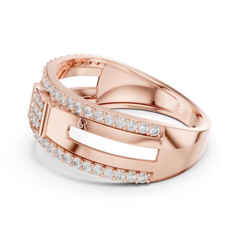 May include: Rose gold ring with a rectangular design and a row of small, clear gemstones. The ring has a polished finish and a small, engraved letter on the side.