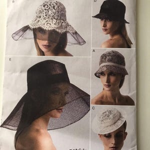 May include: Vogue Patterns accessories package featuring various hat designs. The package includes hats with lace, netting, and structured brims. The designs include a cloche, a wide-brimmed hat, and a hat with a veil. The text "patricia underwood" is visible.