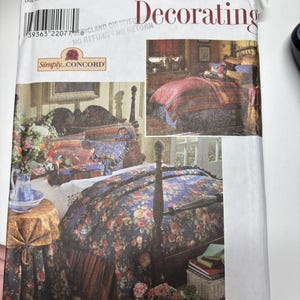 May include: A Simplicity Home Decorating sewing pattern envelope, number 8347, featuring a one size label. The front displays a photograph of a bedroom with a dark blue floral bedspread, a matching skirted side table, and a Simply Concord logo.
