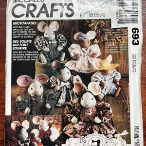 May include: A McCall's Crafts sewing pattern envelope, number 693, featuring illustrations of stuffed mice dolls named Molly and Malcolm. The mice are dressed in various outfits, including plaid overalls, floral dresses, and straw hats. The text includes Micecapades.